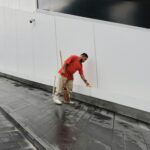Uomo al lavoro sull'impermeabilizzazione di un terrazzo